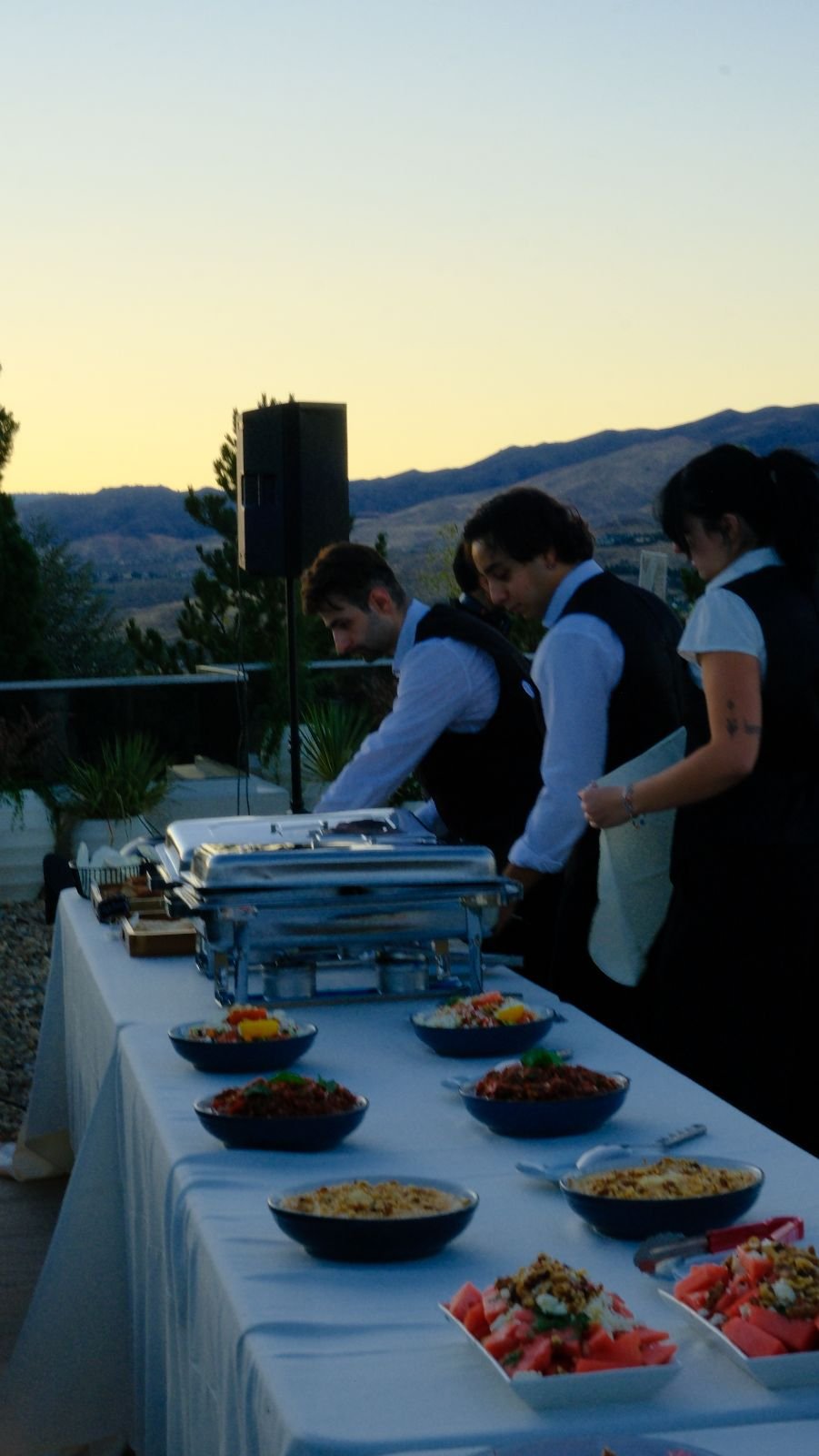 Bora staff preparing a buffet table at dusk